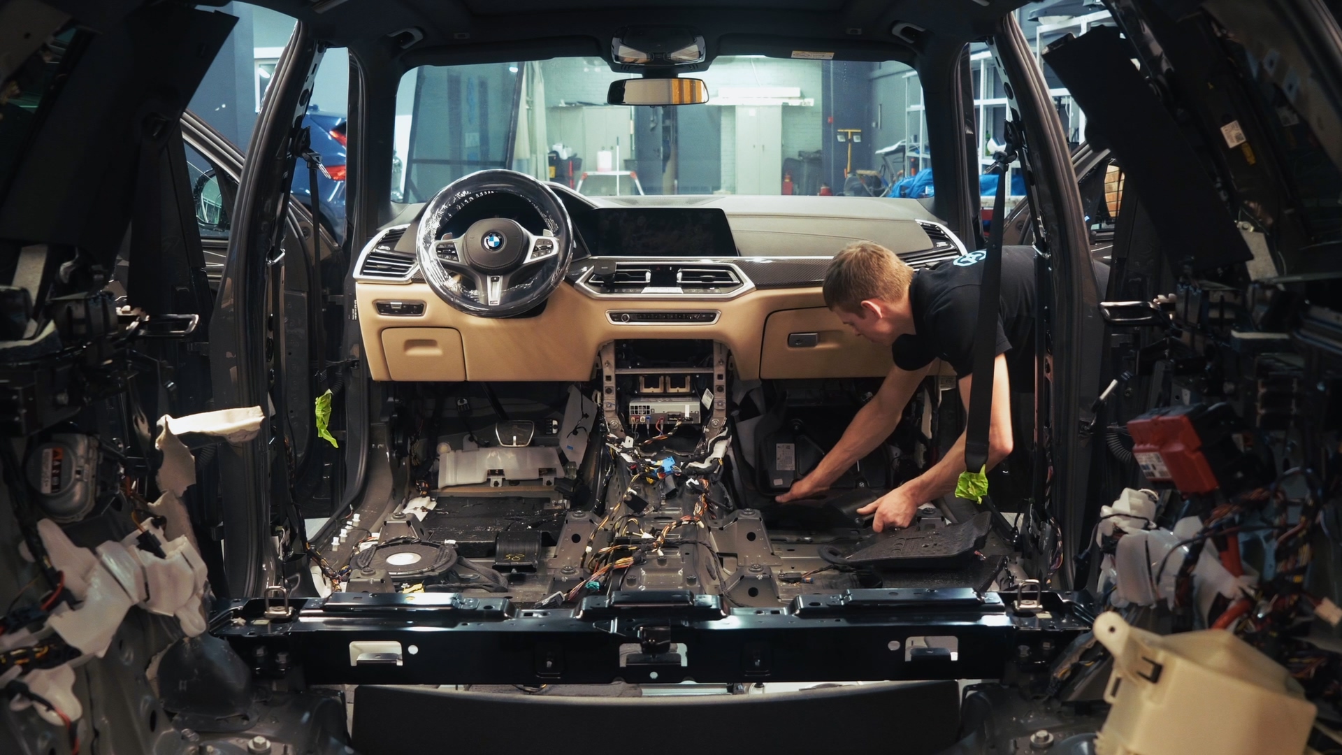 Разобранный салон BMW X5 с мастером в автомобиле