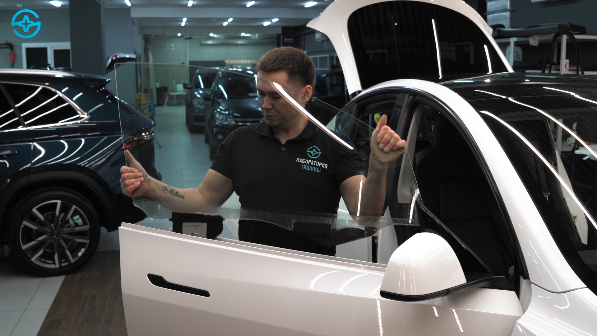 Специалист работает со стеклом двери Tesla